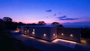A modern building with a pathway leading to the entrance, surrounded by trees. - Workation Resort THE Forest (Nagatoro)