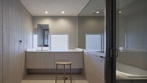 A modern bathroom with a large mirror, a vanity with a sink, a toilet, and a shower area. - Toutou Onzaki Nikai no Yado (Kurashiki)