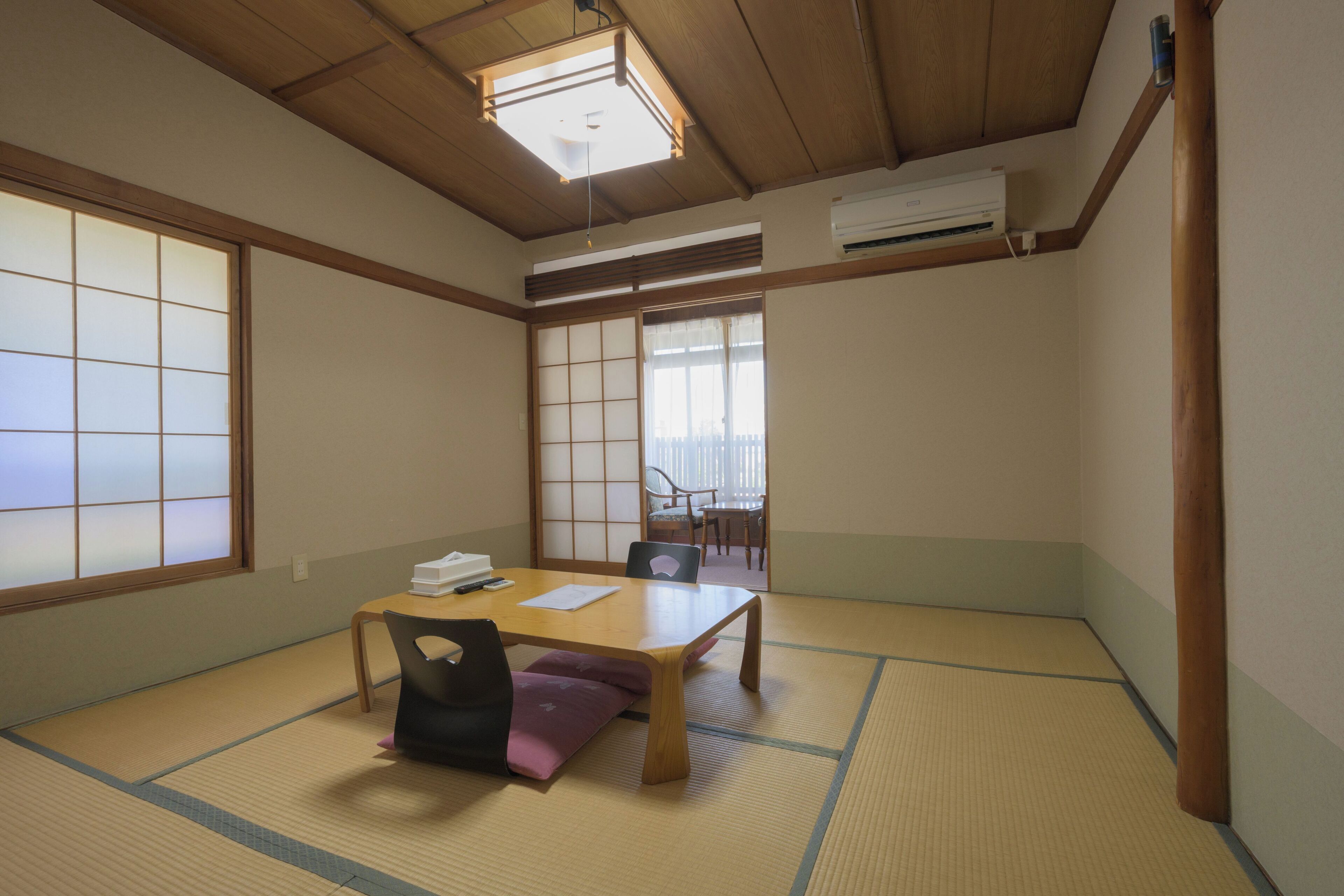 A traditional Japanese room with tatami flooring, a low wooden table, and shoji screens.