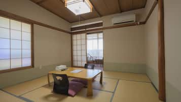 A traditional Japanese room with tatami flooring, a low wooden table, and shoji screens.