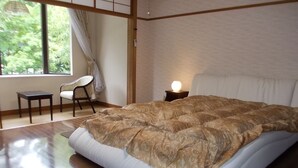 A bedroom with a large bed, a chair, a nightstand with a lamp, and a window with curtains. - Merci 0823 (Ito)