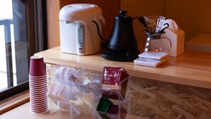 Una encimera de cocina con una cafetera, una balanza y una jarra de vidrio.