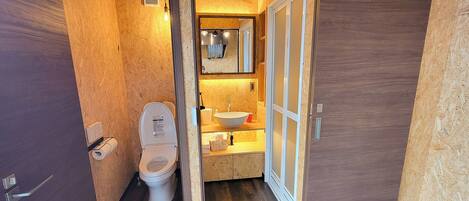 A compact bathroom with a toilet, sink, and mirror.