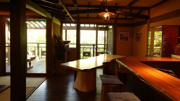 A wooden interior with a central table, benches, and large windows. - Kougetsu Okuyamada Onsen (Takayama)