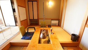 A tatami mat room with a wooden table, a kettle, and a traditional Japanese tea set. - Kougetsu Okuyamada Onsen (Takayama)