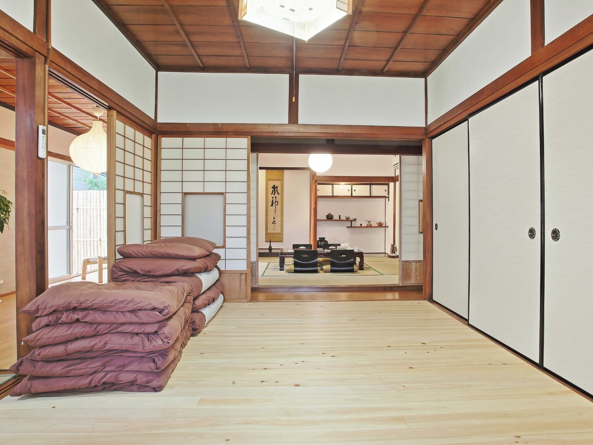 Une pièce de style japonais traditionnel, avec un sol recouvert de tatamis, un plafond bas en bois et des portes coulissantes.