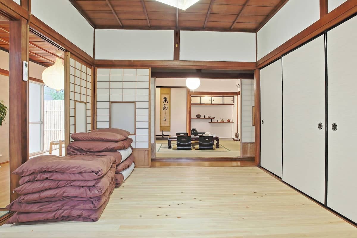 Een traditionele Japanse kamer met tatami vloeren, een laag houten plafond en glijdende deuren.
