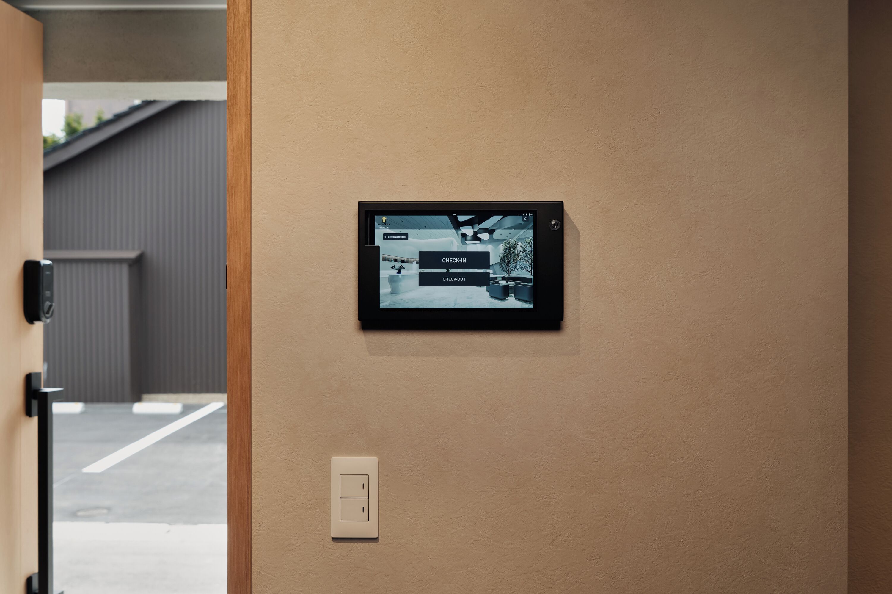 A digital display mounted on a wall with options for 'CHECK-IN' and 'CHECK-OUT'.