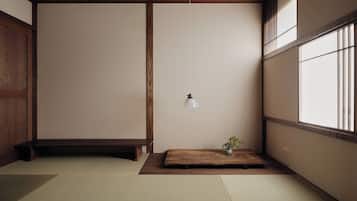 A traditional Japanese room with tatami flooring, a low wooden table with a vase, and a hanging light fixture.