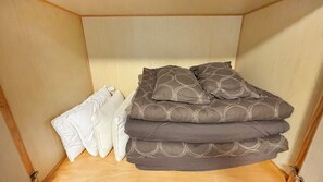 Una cama de madera con colchón y almohadas.