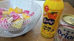 A bottle of Bireley's beer, a can of Orion Draft beer, and a basket of colorful snacks.