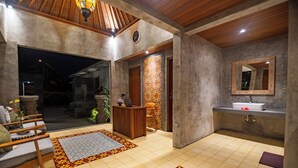 Un baño moderno con lavamanos, espejo y techo de madera.