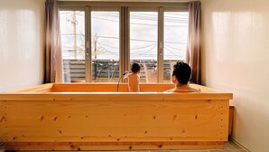 Une pièce avec un grand banc en bois, une fenêtre avec des rideaux et une vue sur l’extérieur.