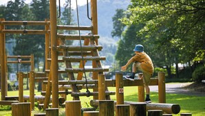 A wooden climbing structure in a park.