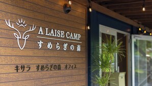 A wooden wall with the text 'A LAISE CAMP' and a deer logo.