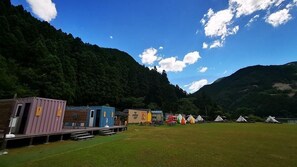 A row of colorful cabins in a mountainous area with a clear sky.