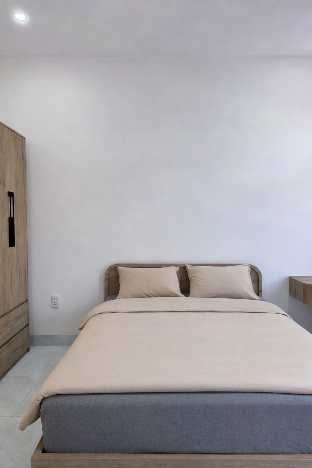 A bedroom with a bed, a wardrobe, and a nightstand.