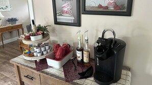 A kitchen counter with a coffee maker, red mugs, and a tray of tea bags. There are two framed quotes on the wall above the counter. - Hilltop Guesthouse - in Intercourse on Beacon Hill, 4-Bedroom House (Ronks)