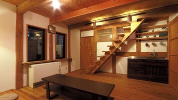 A wooden interior with a staircase, a radiator, and a sink.