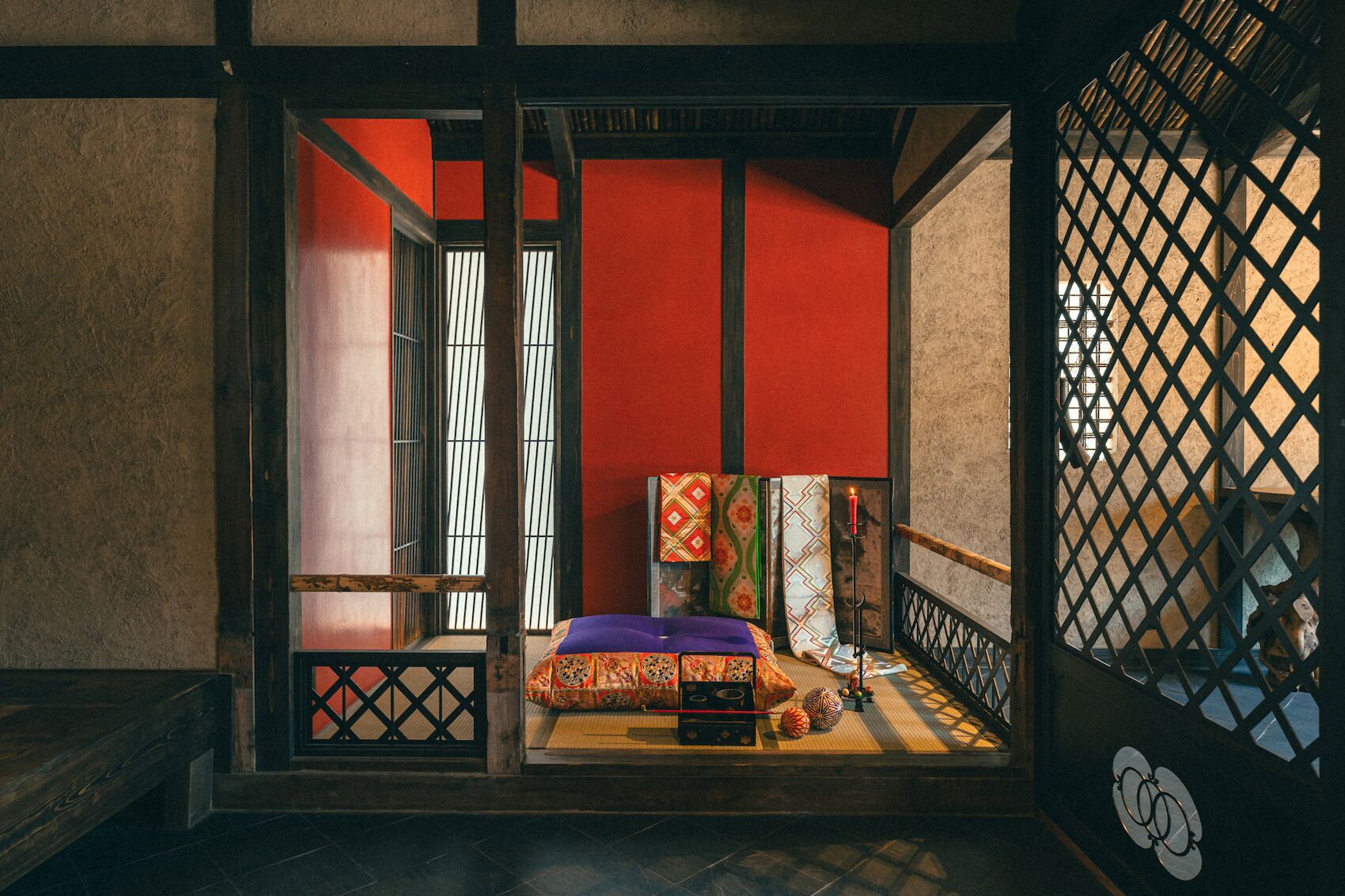 A traditional Japanese room with tatami flooring, a low wooden bed, and sliding doors.