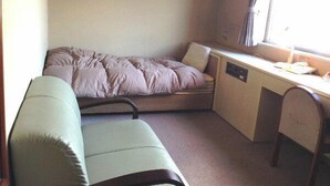 Una habitación pequeña con cama, escritorio y silla.