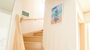 A staircase with a handrail, a wall-mounted sign, and a framed picture. - K-style Resort (Yugawara)