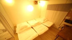Una habitación con una cama, una silla de madera y una mesita.