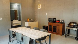 A compact living space with a dining area, kitchenette, and a small entertainment unit. - Glamping Resort ITU (Nasu)