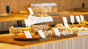 A bakery display with various breads and pastries, including a loaf with a label reading "STAMP."