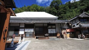 A traditional Japanese building with a tiled roof, wooden beams, and a small porch area. - Hanare Tsukiakari (Minamiise)