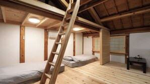 A room with a wooden ladder, two beds, a small table, and a window with a view. - Hanare Tsukiakari (Minamiise)