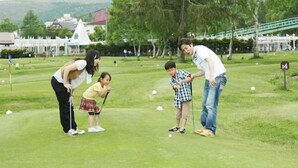 Un campo da golf con una famiglia che gioca.