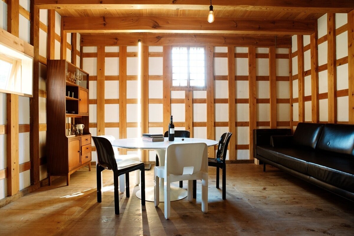 Un interior de madera con una mesa redonda, sillas, un sofá y un armario.