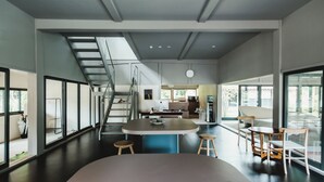 Una cocina moderna con una isla central, taburetes de bar y un comedor con sillas.