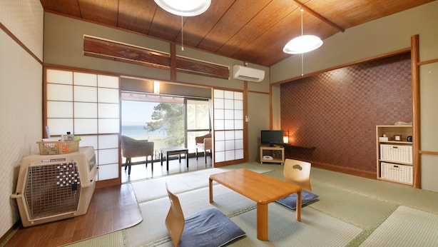 Una tipica stanza giapponese con pavimento in tatami, un tavolino e un televisore.