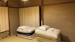 A room with two beds, a ceiling fan, and a wall-mounted air conditioner. - Granny's House (Kozagawa)