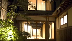 Een traditioneel Japans gebouw met een houten gevel en een centrale binnenplaats.
