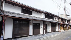 Een traditioneel Japans gebouw met een pannendak, houten balken en schuifdeuren.