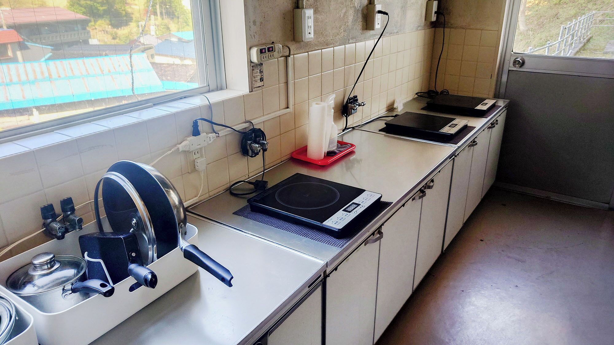 A kitchen with a stove, sink, and window.