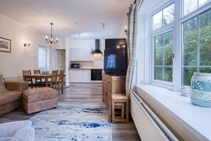 Una sala de estar acogedora con un sofá, un televisor y un comedor con sillas y una mesa.