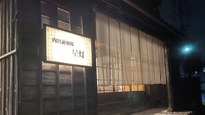 A building with a signboard, wooden exterior, and a gravel pathway. - Aizu Nanokamachi INN (Aizuwakamatsu)