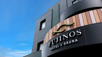 A modern building with a sign for 'Fujinos Hotel & Sauna'.