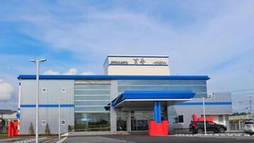 A modern building with a blue and white color scheme, large glass windows, and a prominent entrance with a blue canopy.