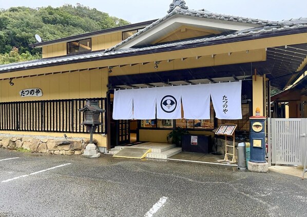 Um edifício tradicional japonês com telhado de telhas e uma placa com a inscrição 