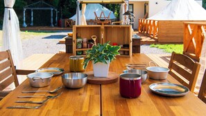 A wooden table with various kitchenware, including bowls, spoons, and a potted plant. - Cocohare (Unzen)