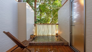 Un'area idromassaggio piccola e privata con un decking in legno, una panca e una tenda.