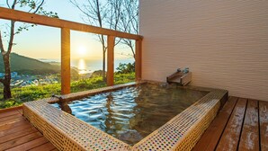 Una vasca idromassaggio con un pontile in legno e vista sul tramonto sull'oceano.