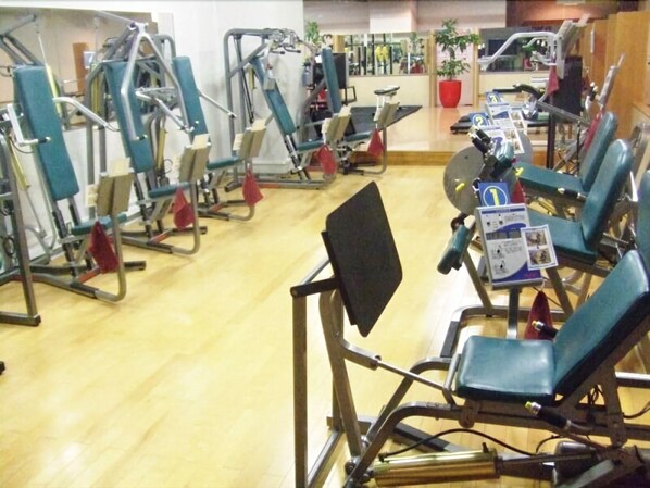 Een sportschool met diverse fitnessapparaten en trainingsmaterialen.
