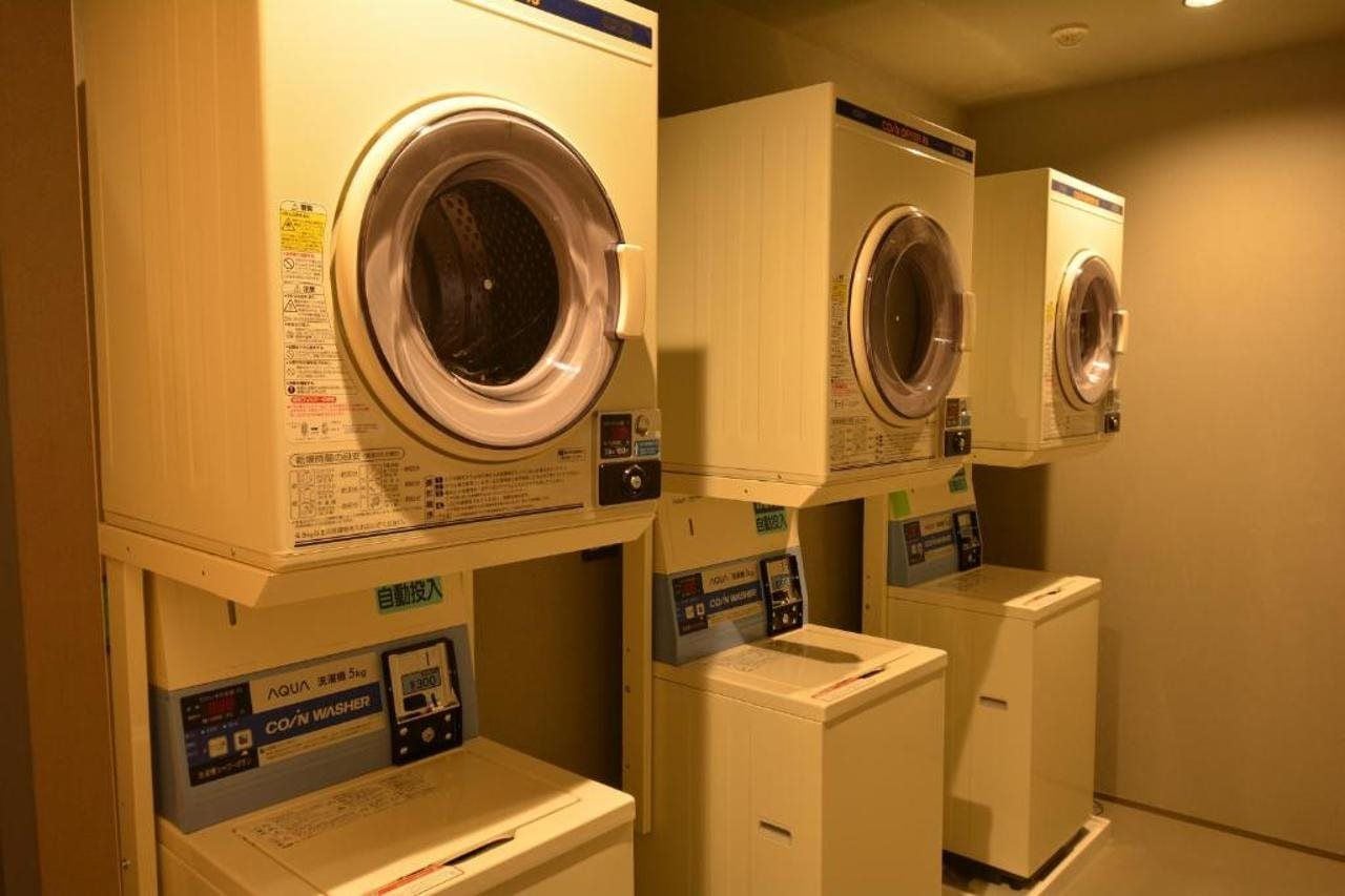 A laundry facility with stacked washing machines and dryers.