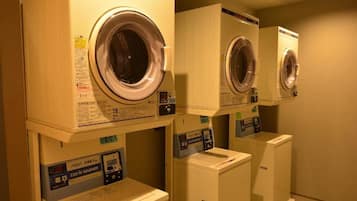 A laundry facility with stacked washing machines and dryers.